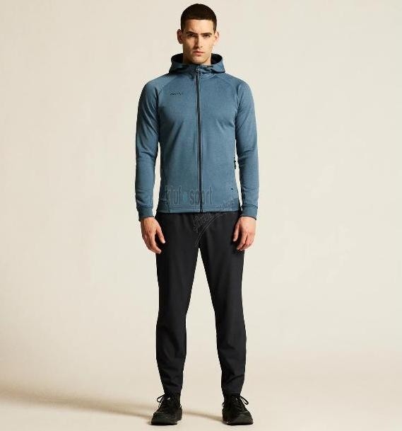 Męski dres sportowy z linii premium Craft ADV Unify – niebieska rozpinana bluza z kapturem i czarne spodnie dresowe o technicznym wykończeniu.