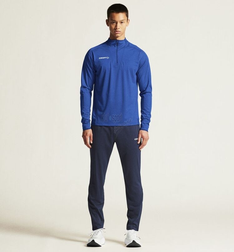 Męski dres treningowy Craft Evolve 2.0 – niebieska bluza treningowa z krótkim zamkiem (half-zip) oraz dopasowane granatowe spodnie treningowe.