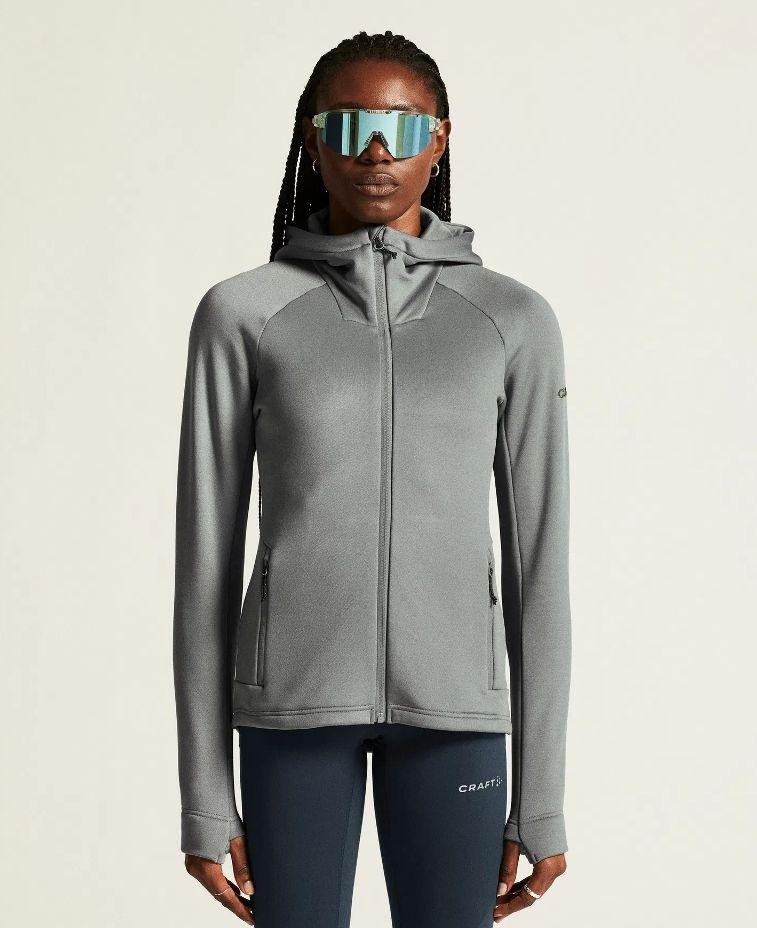 Damska kurtka sportowa Craft ADV Explore Power Fleece w kolorze szarym – techniczna bluza z kapturem, taliowana, z logo Craft na piersi.