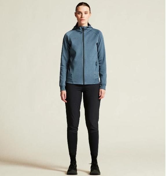 Damski dres sportowy z linii premium Craft ADV Unify – niebieska bluza z kapturem rozpinana na zamek i czarne spodnie sportowe o ekskluzywnym wykończeniu.