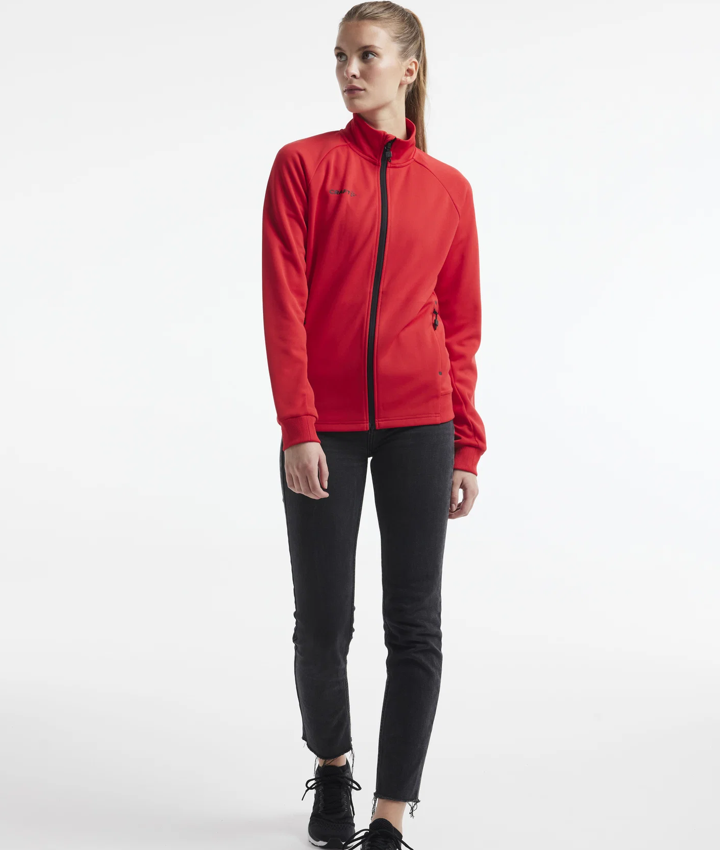 Damski dres sportowy z linii premium Craft ADV Unify – czerwona rozpinana bluza ze stójką i czarne spodnie treningowe o luksusowym wykończeniu.