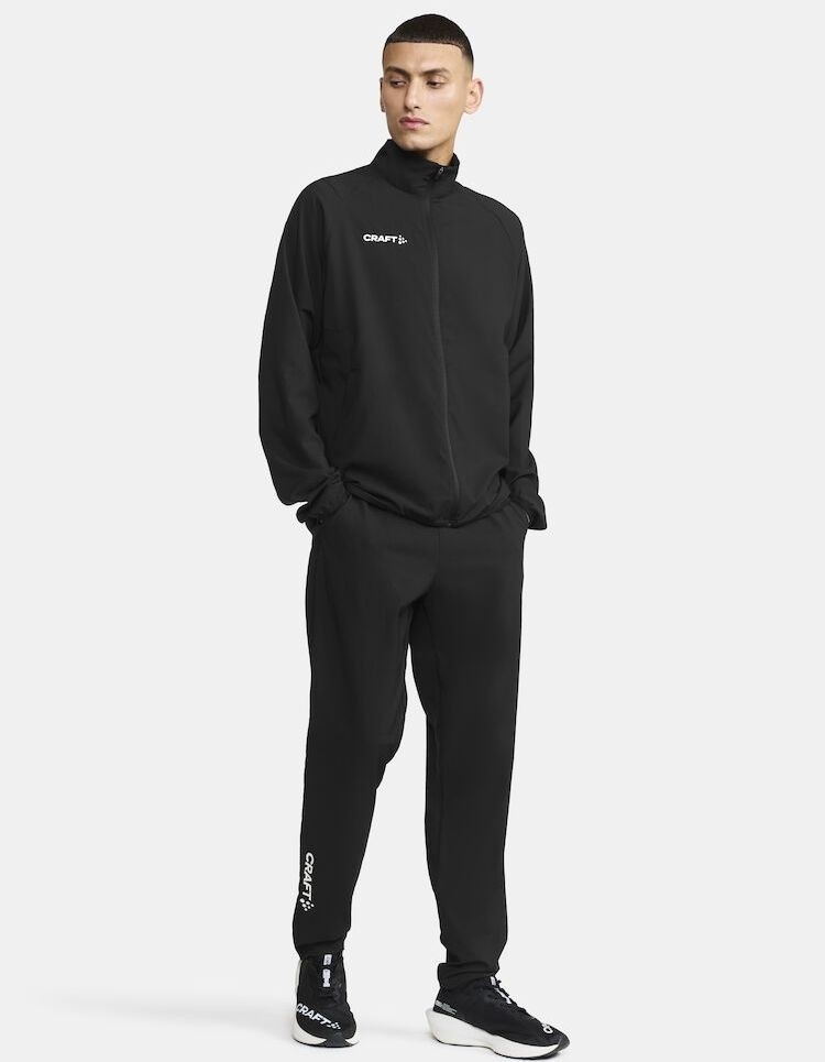 Męski dres treningowy Craft Rush 2.0 w kolorze czarnym – techniczna bluza rozpinana i spodnie sportowe z delikatnym logo Craft na piersi i udzie.