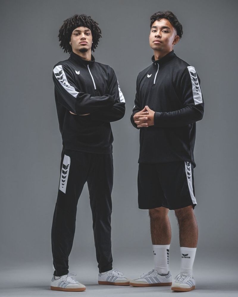 Męski dres treningowy Erima Intro – czarna bluza treningowa z krótkim zamkiem pod szyją oraz czarne spodnie dresowe z białym logo.