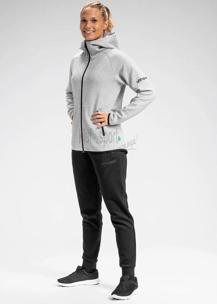 Damski dres sportowy uhlsport id popielato czarny składający się z rozpinanej, jasnoszarej bluzy z kapturem oraz dopasowanych czarnych spodni ze ściągaczami.