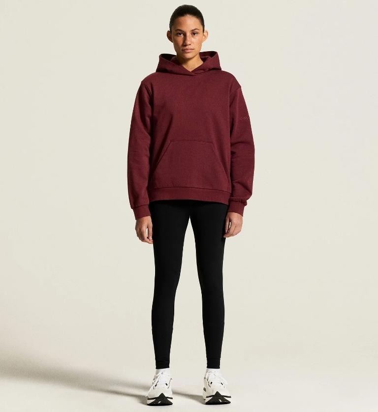 Damski dres treningowy Craft Community 2.0 – bordowa bluza z kapturem wkładana przez głowę i czarne przylegające spodnie treningowe typu Slim.