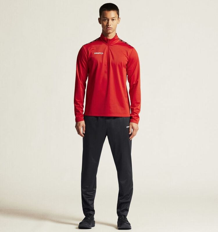 Męski dres treningowy Craft Squad Go – czerwona bluza z krótkim zamkiem pod szyją oraz czarne spodnie treningowe o technicznym kroju.