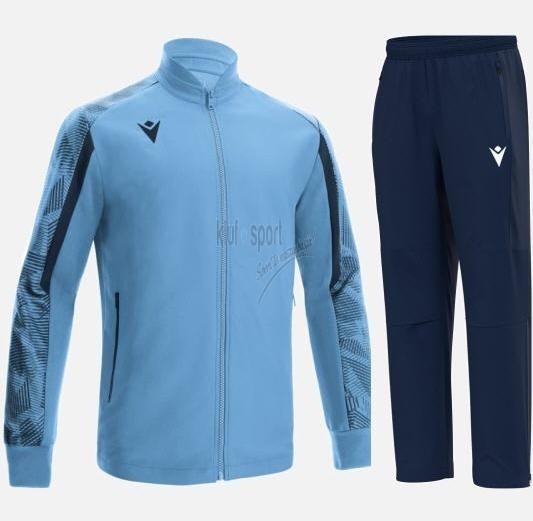 Męski błękitny dres sportowy Macron Achilles Exclusive z geometrycznym wzorem na rękawach i granatowymi spodniami.