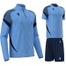 Męski komplet treningowy Macron Starfall – niebieska bluza z zamkiem pod szyją, niebieska koszulka meczowa Totem oraz granatowe spodenki sportowe Skara.