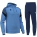 Męski dres sportowy Macron Alchemist błękitna bluza z kapturem i granatowe spodnie
